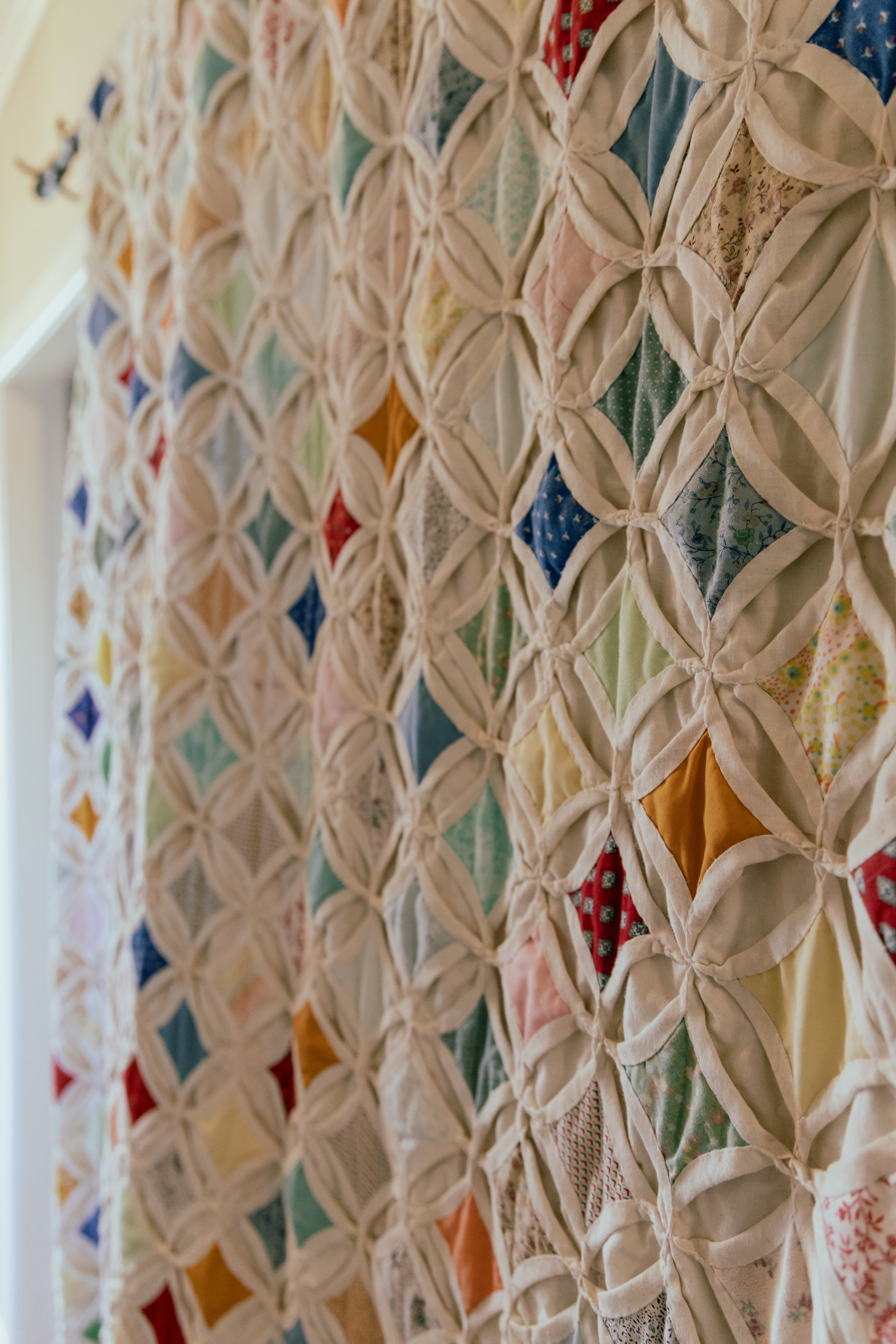Quilted heirlooms displayed in a light-filled modern home hallway