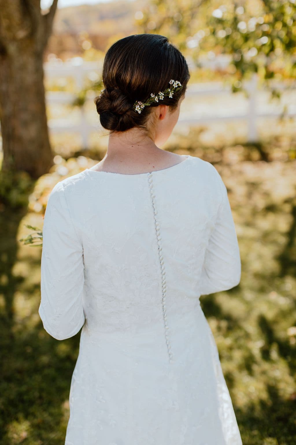Bride wearing an elegant lace wedding gown with pearl buttons before the ceremony.