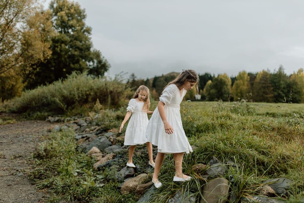 2 flower girls having fun exploring the farm and riverbank where they attended a wedding in Hawke's Bay